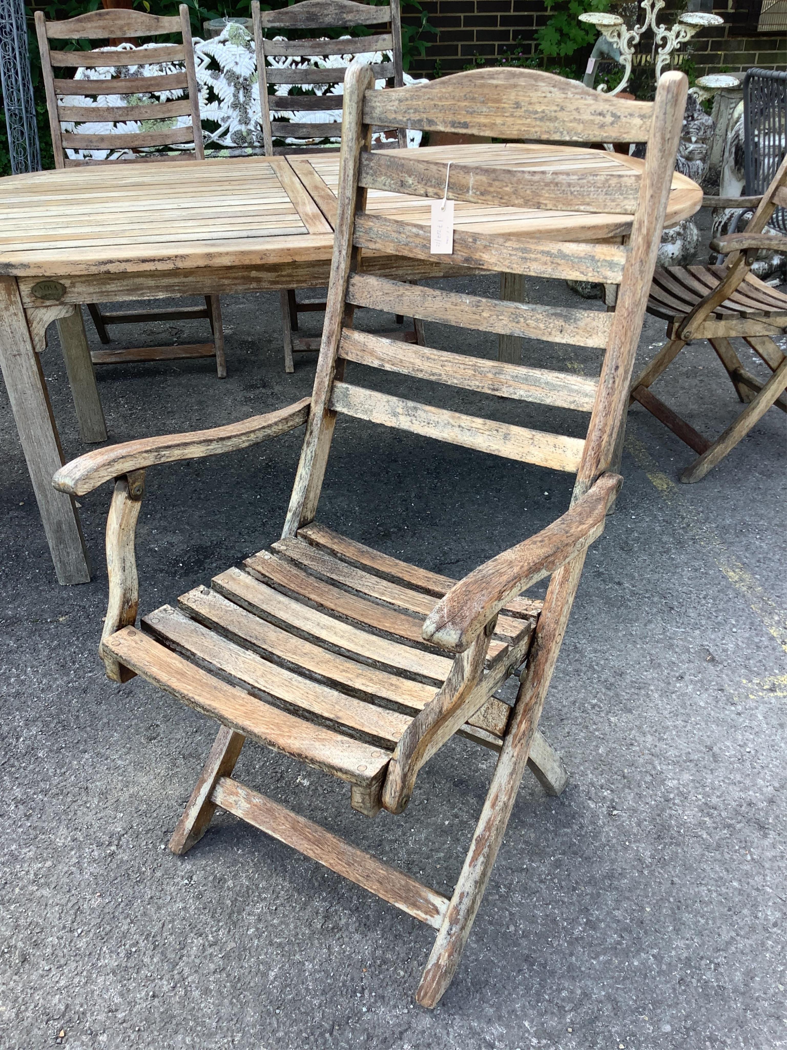 A weathered slatted teak Nova extending garden table, width 240cm extended, depth 100cm, height 71cm and six teak Alexander Rose folding chairs